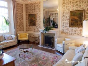 - un salon avec un canapé et une cheminée dans l'établissement La Maison Rouge Brocéliande, à Montauban-de-Bretagne