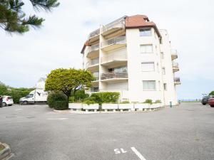 un gran edificio de apartamentos blanco con aparcamiento en Apartment Gulf Stream by Interhome en Biarritz