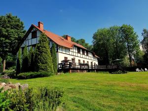 a large white house on a green field at Agroturystyka DoWoli in Świeradów-Zdrój