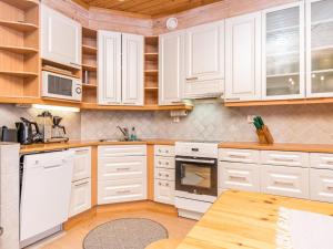ルカにあるHoliday Home Rukassos b by Interhomeの白いキャビネットと木製テーブル付きのキッチン