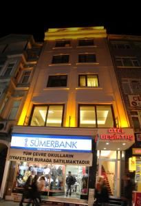 a tall building with a sign in front of a store at Besiktas Otel in Istanbul