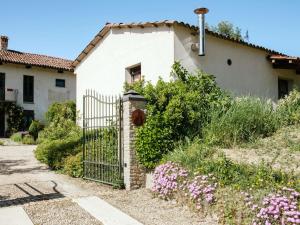 a white house with a gate and flowers at Holiday Home I Grilli by Interhome in Castagnole Lanze