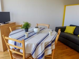 mesa de comedor con mantel de rayas azul y blanco en Apartment Océanic-1 by Interhome, en Biarritz
