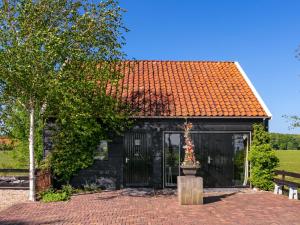 un pequeño cobertizo negro con techo naranja en Holiday Home Polderzicht by Interhome, en Zuid-Beijerland