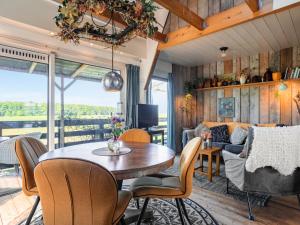 a living room with a table and chairs and a couch at Holiday Home Polderzicht by Interhome in Zuid-Beijerland