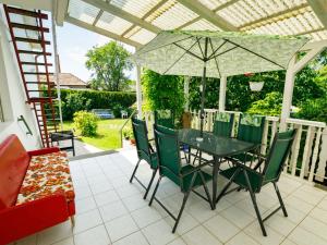 a table and chairs with an umbrella on a patio at Apartment Casablanca 1 by Interhome in Balatonszemes