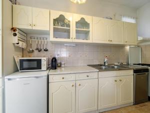 a kitchen with white cabinets and a sink and a microwave at Apartment Casablanca 1 by Interhome in Balatonszemes