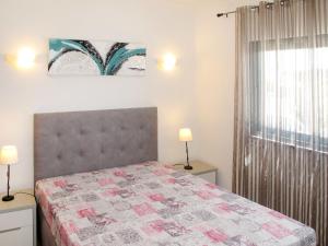 a bedroom with a bed with a quilt on it at Holiday Home Do Pinheiros by Interhome in Vau