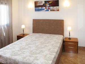a bedroom with a bed with two night stands and two lamps at Holiday Home Do Pinheiros by Interhome in Vau