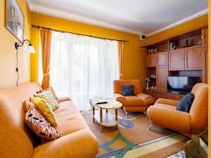 sala de estar con muebles de color naranja y TV en Holiday Home Verde by Interhome, en Balatonlelle