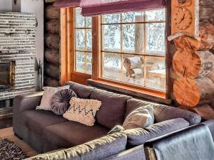 een woonkamer met een bank voor een raam bij Holiday Home Riekonmella by Interhome in Ruka
