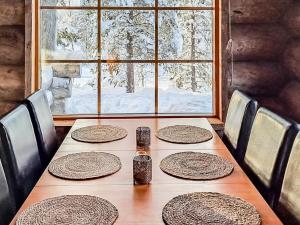 een houten tafel met borden en een raam bij Holiday Home Riekonmella by Interhome in Ruka