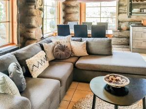 een woonkamer met een bank en een tafel bij Holiday Home Riekonmella by Interhome in Ruka