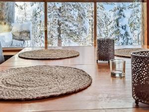 een houten tafel met drie grote ronde platen erop bij Holiday Home Riekonmella by Interhome in Ruka