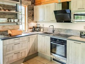 een keuken met houten kasten, een wastafel en een fornuis bij Holiday Home Riekonmella by Interhome in Ruka +16 foto's