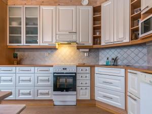 uma cozinha com armários brancos e um forno em Holiday Home Rukassos a by Interhome em Ruka