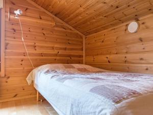 um quarto com uma cama numa parede de madeira em Holiday Home Rukassos a by Interhome em Ruka