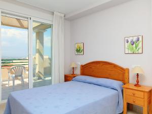 Habitación blanca con cama y balcón. en Apartment Navegantes by Interhome, en Peñíscola