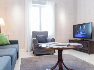 a living room with a tv and a coffee table at Holiday Home Villa einola by Interhome in Nilsiä