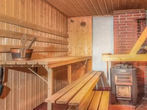 uma sauna de madeira com um banco e um fogão em Holiday Home Koivuranta by Interhome em Räätäniemi