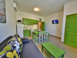 ein Wohnzimmer mit einem Sofa und eine Küche mit grünen Schränken in der Unterkunft Apartment Val-1 by Interhome in Sveti Juraj
