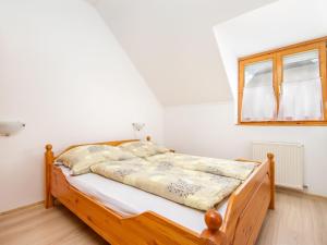 1 dormitorio con cama de madera y ventana en Apartment Katie 1 by Interhome en Balatonmáriafürdő