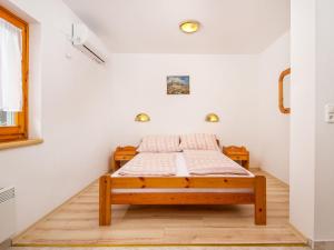 バラトンマーリアフュルドゥーにあるStudio Amarillo 2 by Interhomeの白い壁とウッドフロアの客室のベッド1台分です。