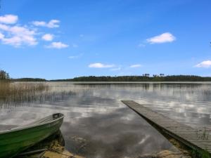 un bateau assis sur l'eau à côté d'un quai dans l'établissement Holiday Home Rantapelto by Interhome, à Heinälahti