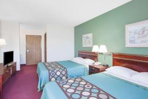 a hotel room with two beds and a flat screen tv at Super 8 by Wyndham Kennett in Kennett