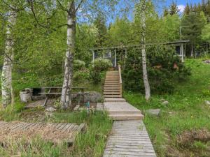 eine Holztreppe, die zu einem Gebäude im Wald führt in der Unterkunft Holiday Home Rantapelto by Interhome in Heinälahti