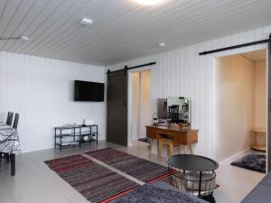 ein Wohnzimmer mit einem Tisch und einem Schreibtisch in der Unterkunft Holiday Home Rantapelto by Interhome in Heinälahti