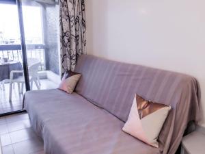 a couch with two pillows on it in a living room at Apartment Les Deux voiles-1 by Interhome in La Foux