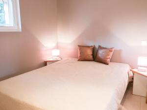 a bedroom with a bed with two pillows on it at Apartment Les Deux voiles-1 by Interhome in La Foux