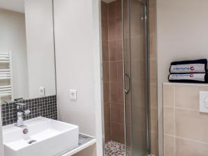 W łazience znajduje się umywalka i prysznic. w obiekcie Apartment Les Deux voiles-1 by Interhome w mieście La Foux