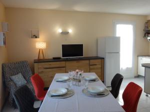 een eetkamer met een witte tafel en rode stoelen bij Apartment Les Jardins de l'Eden by Interhome in Pontaillac