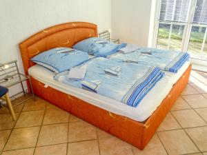 a bed with blue sheets and blue pillows on it at Apartment Gollwitzer Park - Insel Poel-1 by Interhome in Gollwitz