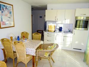 a dining room with a table and chairs and a kitchen at Apartment Gollwitzer Park - Insel Poel-2 by Interhome in Gollwitz