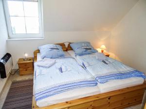 a bedroom with two beds with blue pillows and a window at Apartment Gollwitzer Park - Insel Poel-2 by Interhome in Gollwitz