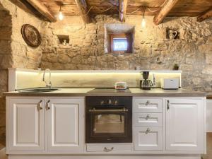 a kitchen with a stove and a stone wall at Holiday Home Susanne by Interhome in Gorica
