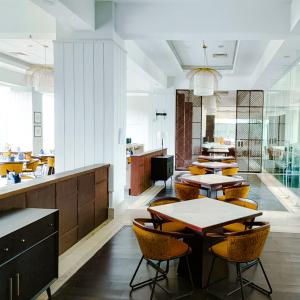 un restaurante con mesas y sillas en una habitación en Suni Hotel and Convention Abepura managed by Parkside, en Tobadi