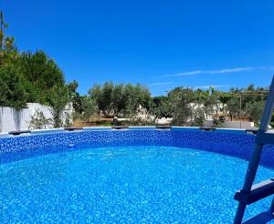 una piscina con acqua blu in un cortile di Villa Mele a Lido Marini