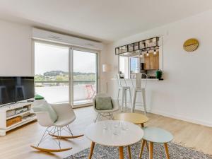 een woonkamer met tafels en stoelen en een televisie bij Apartment Le clos Xapella by Interhome in Bidart