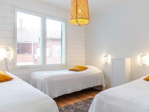Holiday Home Meri-villa by Interhome في Kiviniemi: غرفة بيضاء بسريرين ونافذة