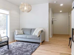 sala de estar con sofá azul y lámpara de araña en Holiday Home Meri-villa by Interhome en Kiviniemi