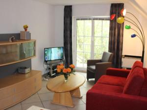 a living room with a red couch and a tv at Apartment Gollwitzer Park - Insel Poel-3 by Interhome in Gollwitz