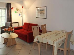 a living room with a red couch and a table at Apartment Gollwitzer Park - Insel Poel-3 by Interhome in Gollwitz
