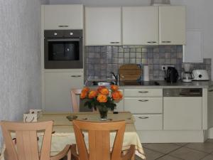a kitchen with a table with a vase of flowers on it at Apartment Gollwitzer Park - Insel Poel-3 by Interhome in Gollwitz