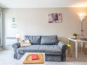 ein Wohnzimmer mit einem blauen Sofa und einem Tisch in der Unterkunft Studio Victoria Surf-11 by Interhome in Biarritz