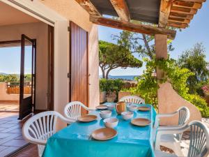 - une table bleue avec des chaises blanches sur la terrasse dans l'établissement Holiday Home La Petite Afrique by Interhome, aux Issambres
