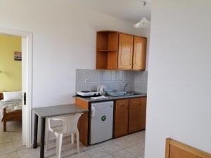 a kitchen with wooden cabinets and a table and a stove at Andreas Apartments in Kefalos